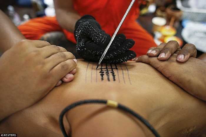 Các nhà sư dùng thép nhọn để truyền những quyền lực huyền bí thông qua hình xăm cho các tín đồ