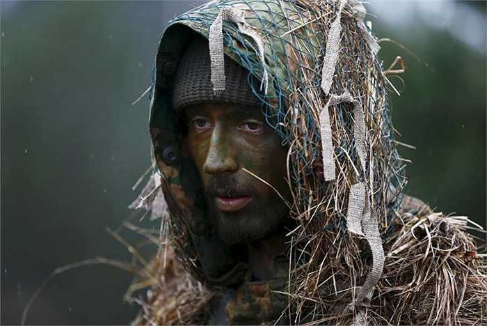 Một dân quân hóa trang để hòa mình vào rừng