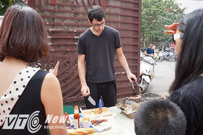 Anh chàng này chuyên bán xúc xích nướng của Pháp và được rất nhiều khách đến mua hàng. Từ người lớn đến trẻ em đều thích thú với món ăn này cũng như khá ấn tượng với chiều cao và nụ cười tươi của anh.