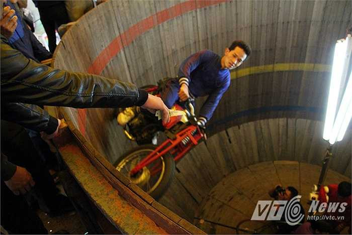 Khán giả thường chìa tiền ra để ‘thách đố’ các tay lái có thể lấy được, nhưng thật ra, đó là cách để họ ‘thưởng’ cho các tay lái sau những màn trình diễn mãn nhãn.