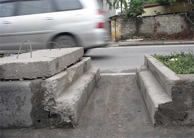 Tấm bê tông dùng che khe thoát nước giữa dải phân cách cũng bị tháo ra để làm lối đi cho xe đạp, xe máy.