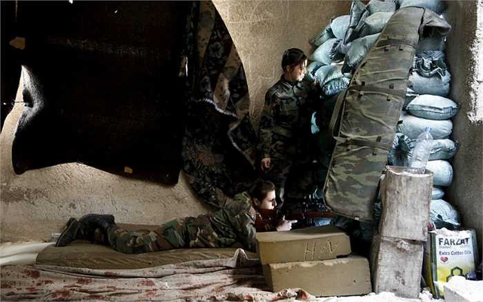 Nấp sau bức tường dựng lên từ những bao cát, một người đang nhằm thẳng mục tiêu trong khi người kia quan sát chiến trường Jobar.