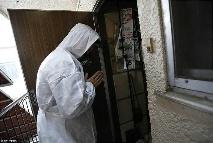 Hirotsugu Masuda, 1 nhân viên dọn rác đang cầu nguyện trước khi bước vào căn hộ.