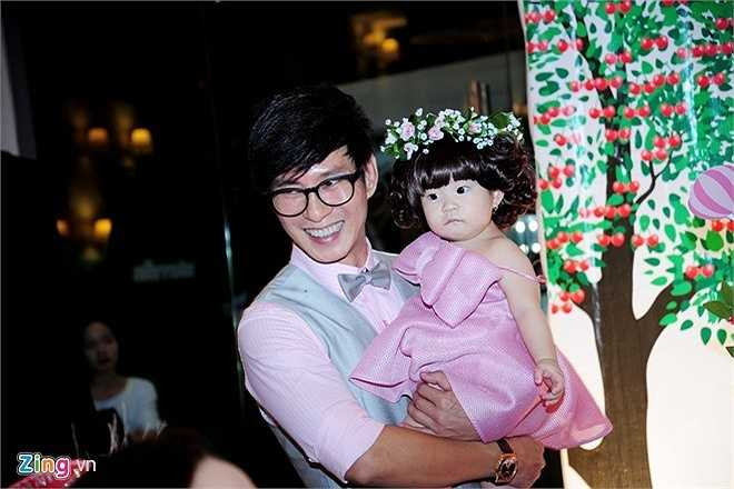 Cherry được mẹ cho đội tóc giả và đeo vòng hoa trên đầu. Cô nhóc liên tục được ba mẹ bế ẵm đi chào hỏi quan khách