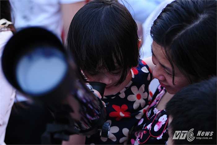 Bé gái được mẹ cho ngắm kính thiên văn