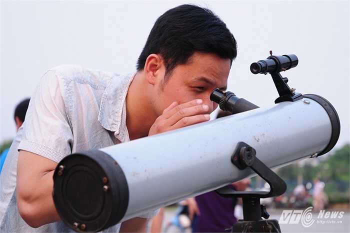 Một thanh niên thử nhìn vào kính thiên văn tự chế