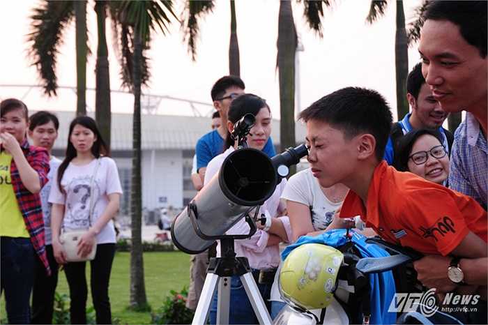 Em bé được bế lên để nhìn vào kính