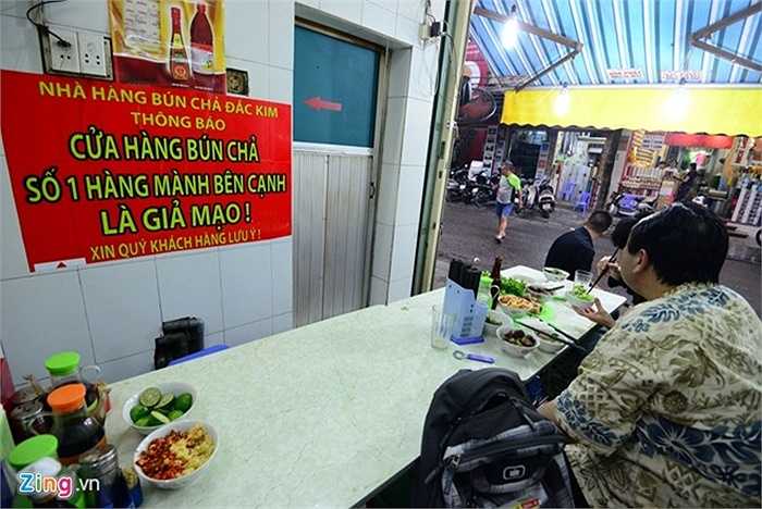 Để phân biệt thật giả lẫn lộn, chủ cửa hàng bún chả 'xịn' đã treo biển thông báo với nội dung: 'Cửa hàng bún chả số 1 Hàng Mành bên cạnh là giả mạo! Xin quý khách lưu ý'.