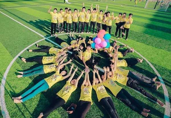 Đồng phục lớp nổi bật trên nền xanh của sân vận động. Đây là nơi để lại nhiều kỷ niệm sau những trận thi đấu thể thao. 