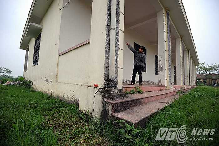 Ông T, một người dân sống cạnh khu vực trường học đang chỉ cho phóng viên những chỗ mảng tường, bậc tam cấp của tòa nhà bị nứt vỡ, mặc dù ngôi trường chưa hề được đưa vào sử dụng.