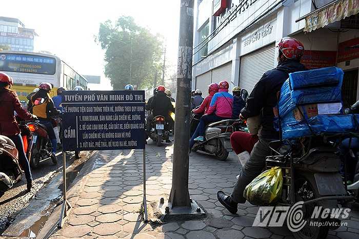 Chiều rộng mặt đường bị thu hẹp khiến cho các phương tiện chủ yếu là xe máy phải leo lên vỉa hè để lưu thông.