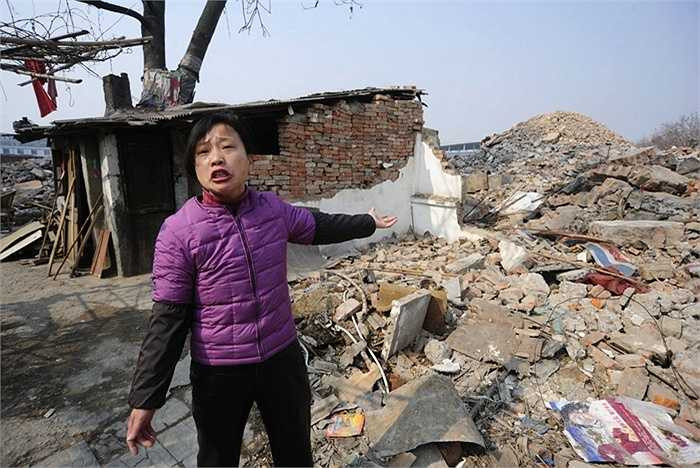 Cô Cao Mingyun và ngôi nhà của mình ở Hợp Phì, An Huy, Trung Quốc vào năm 2010. Gia đình cô từ chối chuyển đi do không nhất trí với mức bồi thường của chủ dự án thương mại đưa ra.