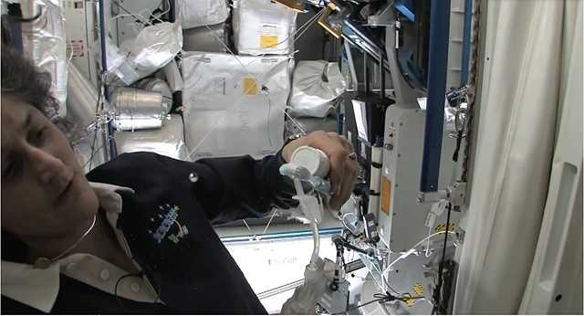 Một phi hành gia chuyển nước từ vòi vào bàn chải để đánh răng.