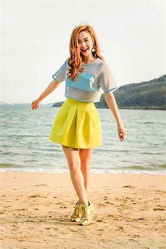 Minh Hằng tươi tắn đón nắng trên bãi cát vàng với áo xuyên thấu và váy ngắn. 