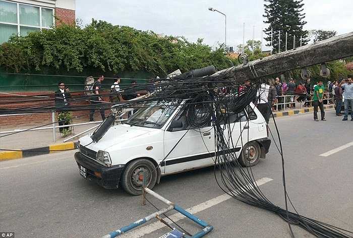 Một chiếc ô tô bị cột điện đè trúng