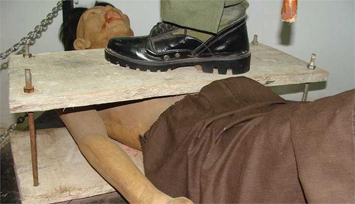 Bọn cai ngục dùng 2 tấm ván ép vào ngực và lưng tù nhân, rồi xiết bù loong hai đầu làm tù nhân vỡ lồng ngực, vỡ tim, tắt thở.