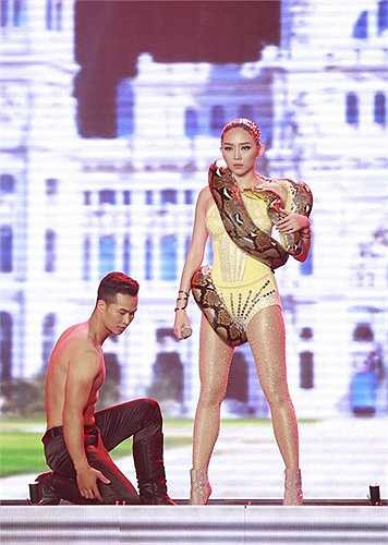 Không ít khán giả nể phục giọng ca hải ngoại khi cô để con trăn quấn quanh người, vừa hát vừa đùa giỡn với 'người bạn' mới. Sau phần mở đầu đầy ấn tượng, vũ công nam giúp nữ ca sĩ đưa 'bạn diễn' vào hậu trường, còn cô tiếp tục biểu diễn máu lửa với vũ đoàn. 