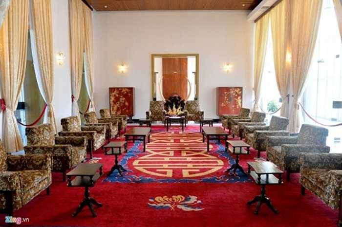 Phòng tiếp khách trải thảm thêu hoa cúc và chữ song hỷ cùng với bức bình phong ngà voi lớn. Hai bên có tủ nhỏ trạm trổ trúc mai.