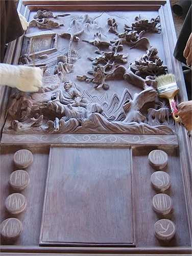 Một bức tranh mô phỏng tích truyện cổ, với dòng câu đối hai bên trong biệt thự gỗ. 