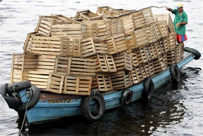 Chiếc thuyền nhỏ chở đầy thùng gỗ 