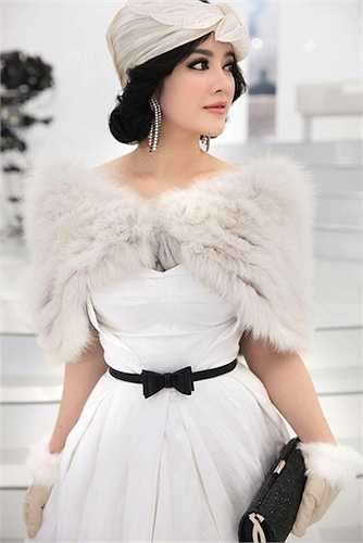 Kết hợp với chiếc khắn quấn cổ bằng lụa trắng, chiếc váy circle của thương hiệu Maticevski cùng với khắn lông găng tay da lộn của Elcom Fur và bông tai Crivelli 