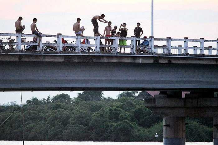 Ban đầu, có 2 người tới trước, sau cuộc điện thoại 'thúc giục' bạn bè. Chừng 15 phút, có từ 5 -10 người nữa tới. Nhóm thanh niên này trèo lên thành cầu có độ cao chừng 15 – 20 mét rồi nhảy xuống giữa sông.