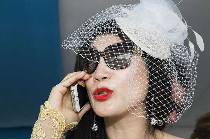 Một phụ nữ giàu có xem polo và nói chuyện qua chiếc iPhone dát vàng