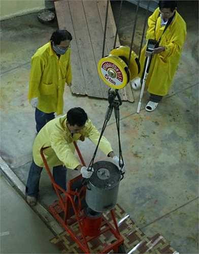 Chuyển đồng vị phóng xạ từ thùng chì sang container vào khu vực điều chế dược phẩm