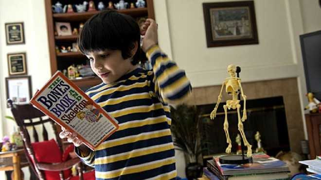 Tanishq Abraham tham khảo cuốn sách yêu thích. Ảnh: Zuma Press.