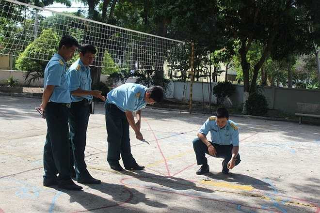 Một nhóm các phi công đang nghiên cứu về bài bay của mình trên khu vực sân rộng có vẽ các đường bay.