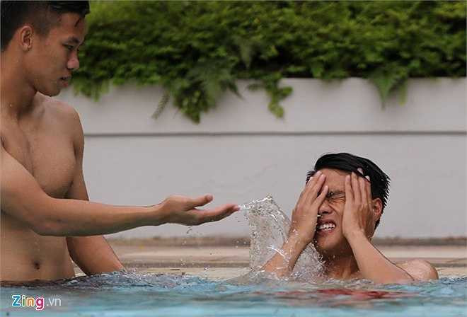 Tiền đạo Việt kiều cũng bị sặc nước khi Ngọc Hải 'hợp sức' với Huy Toàn té nước vào tai và mũi anh.