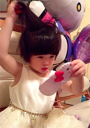 Cô bé đã biết soi gương, dùng son môi cũng như mặc đẹp như một công chúa nhỏ. Gần đây, Nguyệt Cát thường xuyên được mẹ đưa đến các sự kiện của showbiz. (Nguồn: Zing)