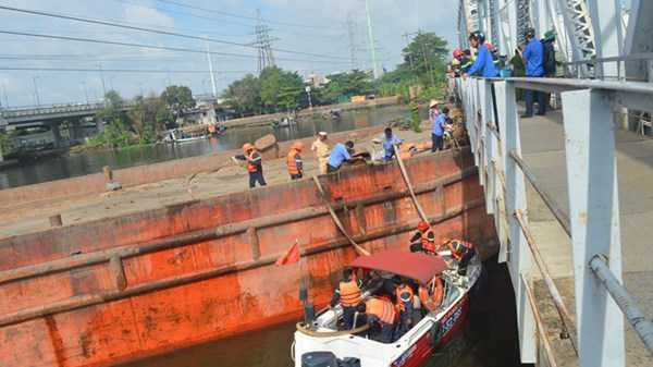 TP.HCM: Giải cứu sà lan hàng trăm tấn mắc kẹt dưới gầm cầu