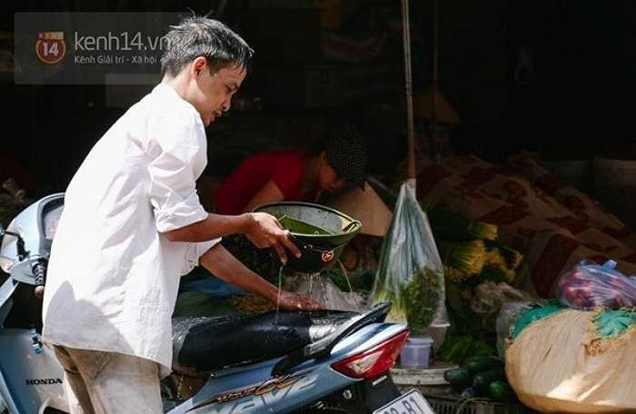 Một người lao động phải dùng mũ cối của mình để múc nước và rưới lên yên xe máy. Một thí nghiệm cho thấy yên da của xe máy có thể lên tới 80 độ C dưới sức nóng của mặt trời - Nguồn ảnh: Trí thức trẻ