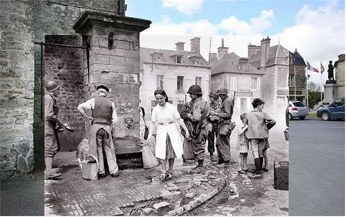 Một nhóm binh lính Mỹ đang đứng tại đài phun nước của một ngôi làng ở Sainte-Marie-du-Mont, Pháp