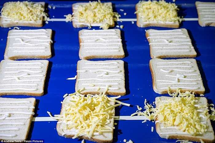 Sau khi đã được quét sốt mayonaise, các bánh mỳ được phủ thêm lớp pho mát bào nhỏ