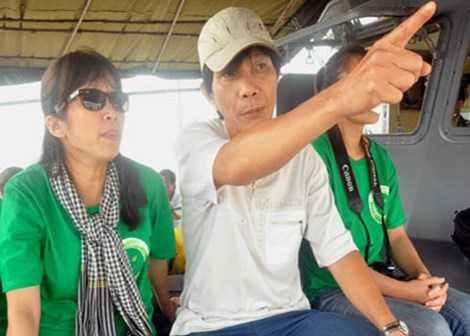 Bí thư Thành ủy Hội An Nguyễn Sự mặc áo thun, đội mũ vải say sưa vào vai hướng dẫn viên cho khách du lịch tham quan đảo Cù Lao Chàm. Ảnh:Trí Tín.