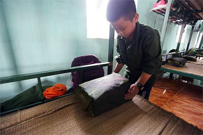 Minh Quân, 9 tuổi , trường tiểu học Vân Yên đã học được cách gập chăn màn vuông vức hình chiếc bánh trưng