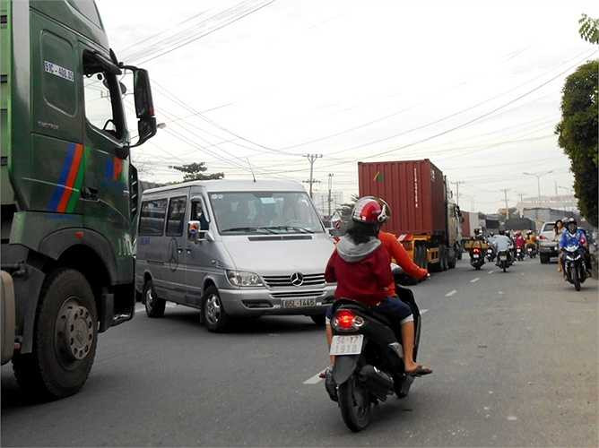 Một ô tô cắt mặt container chen ngang qua đường.