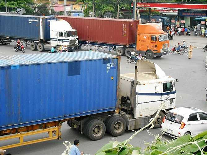 Lực lượng CSGT vất vả điều tiết giao thông khi nhiều xe container lăn bánh cùng lúc.