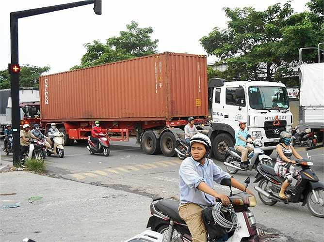 Xe máy di chuyển sát container nguy cơ xảy ra tai nạn giao thông lớn.