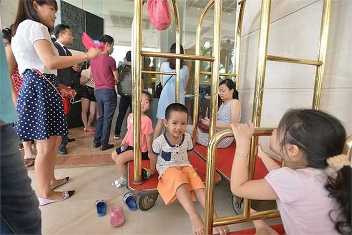 Trẻ nhỏ cũng đi mua sắm cùng bố mẹ. Sáng 20/6, chị Nguyễn Phương Mai cho con đi mua hàng từ 9h, nhưng chờ đến 11h vẫn không được vào. Chị cho biết không thể chen chúc vào mua hàng nên cả 3 mẹ con đành phải ngồi chờ ở sảnh khách sạn. 