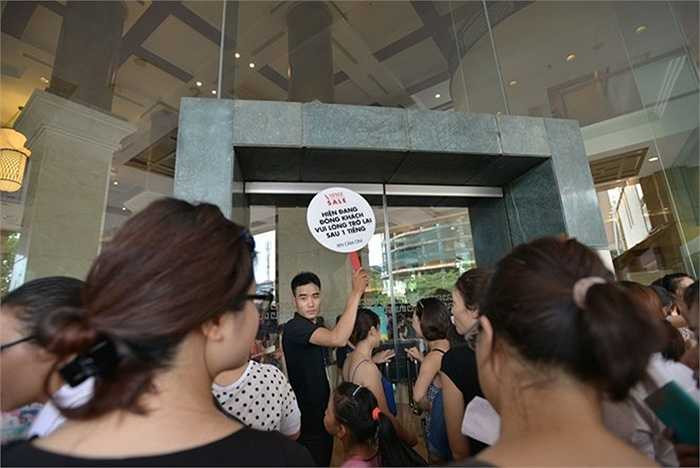 Tại sảnh khách sạn, vào buổi sáng, nhân viên liên tục giơ biển báo yêu cầu khách trở lại sau 1 tiếng vì quá đông, song vẫn không thể ngăn được dòng người đổ đến.