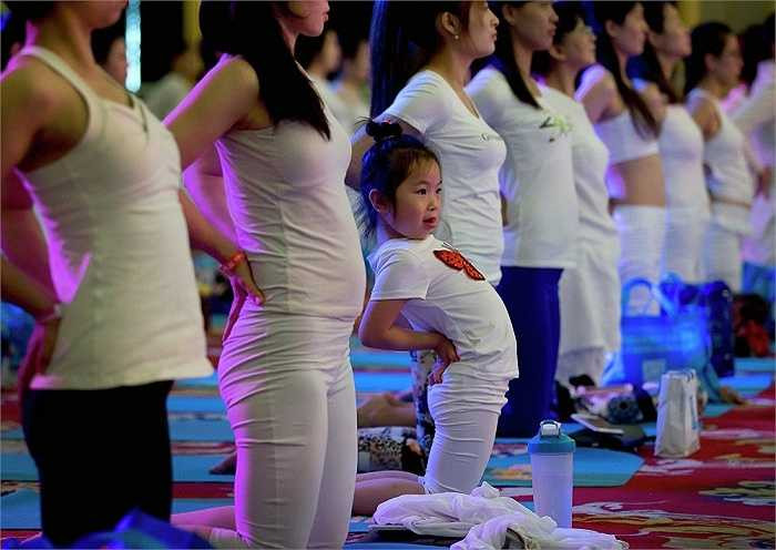 Một bé gái cũng hoà chung với không khí ngày Quốc tế Yoga trong một khách sạn ở quận Xương Bình, Bắc Kinh, Trung Quốc