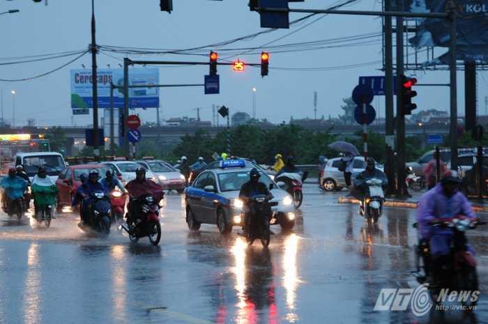 Ô tô, xe máy chạy hối hả qua vũng nước ngập