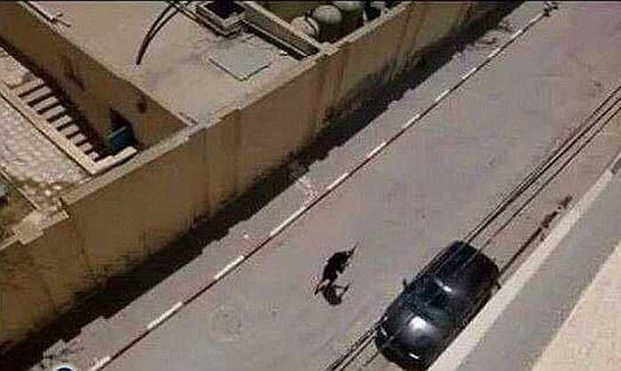 Tên khủng bố cầm súng di chuyển trên đường phố