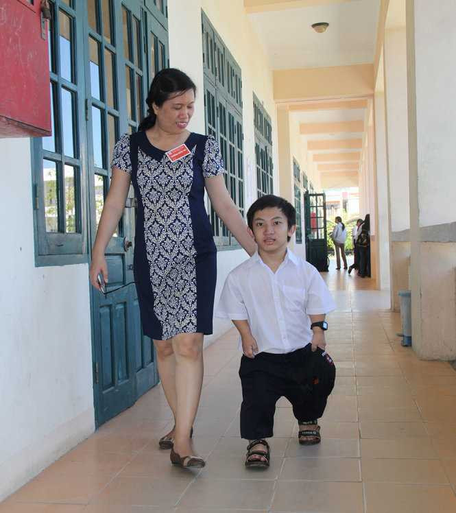 PGS.TS Trương Thị Diễm, trưởng điểm thi khu H Trường ĐH Bách khoa Đà Nẵng đưa thí sinh Nguyễn Đình Phước chọn bàn thi- Ảnh: Trường Trung