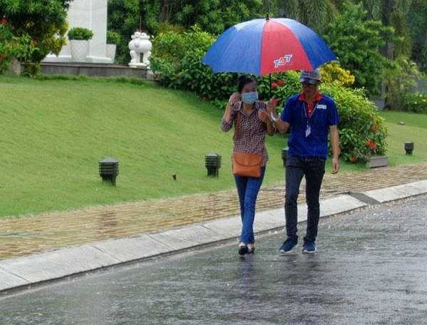 Tình nguyện viên đưa đón thí sinh đến phòng thi để tránh bị ướt mưa - Ảnh: Internet