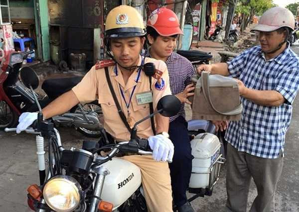 Một cảnh sát giao thông giúp một sĩ tử bị hư xe - Ảnh: Sơn Dương