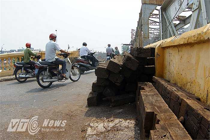 Trên mặt cầu, những thanh tà vẹt cũ đã mục nát, hỏng sẽ được tháo bỏ để thay thế.